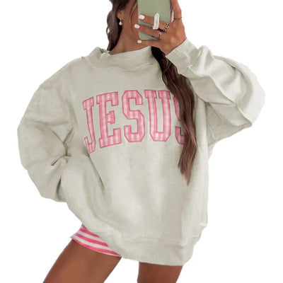 Woman wearing light gray oversized crewneck sweatshirt with pink polka dot lettering